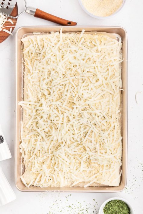 Pizza dough with seasonings and cheeses.