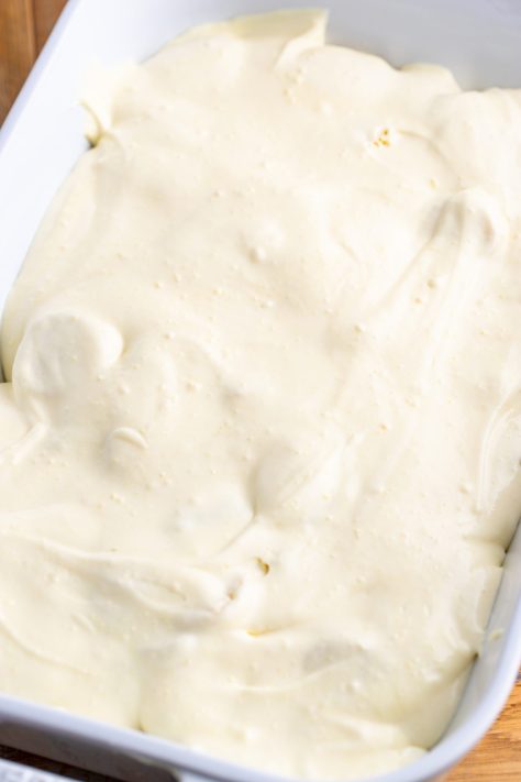 Pudding mixture with bananas and pound cake in a baking dish.