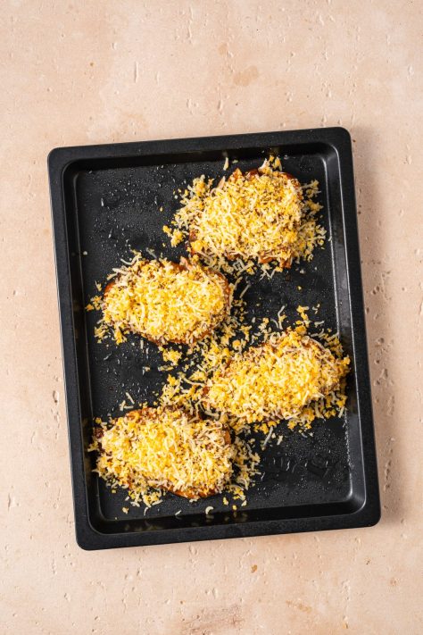 Shredded cheeses on sliced bbq coated chicken breasts.