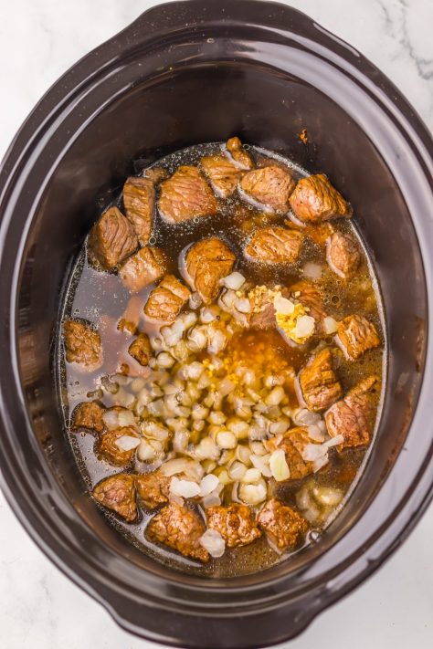 Beef, garlic, and oil in a Slow Cooker.