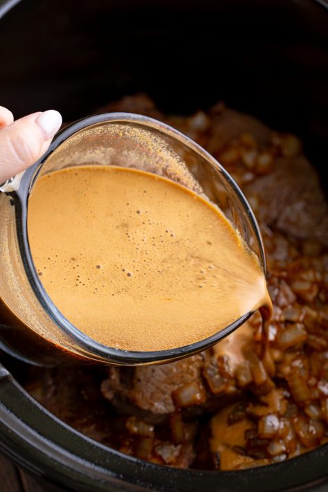 A measuring cup with Worcestershire sauce, water, and packets of gravy mix.