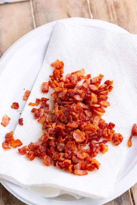 Cooked bacon on a paper towel lined plate.