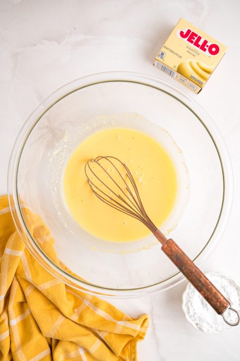 A bowl with vanilla pudding mix, vanilla extract, and milk whisked together.
