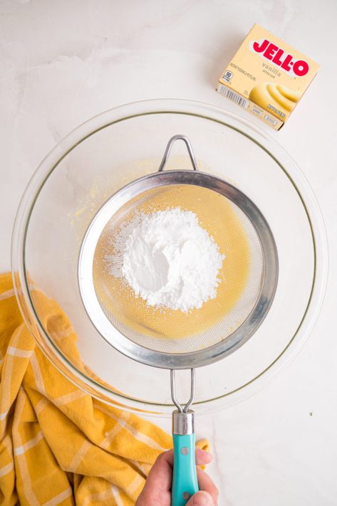 Powdered sugar being sifted into a pudding mixture.