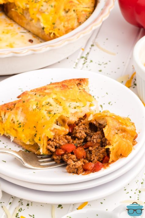 A plate with a serving of Cheesy Beef Pockets with a fork.