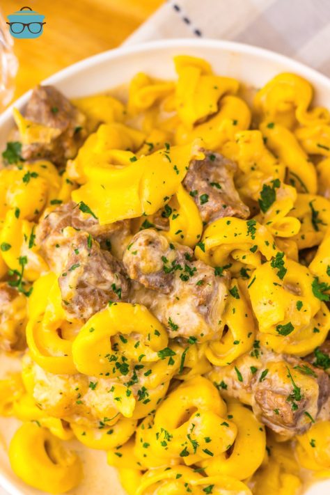 Looking down on a bowl of Crock Pot Steak Bites and Tortellini.