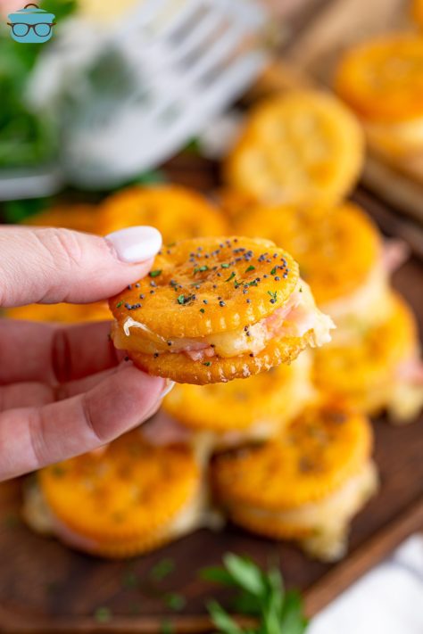 A hand holding a Ritz Cracker Sandwich.