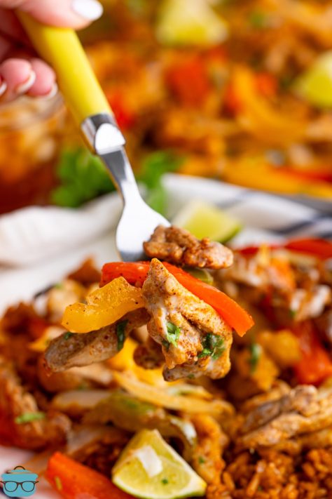 A utensil getting a scoop of Sheet Pan Chicken Fajitas.
