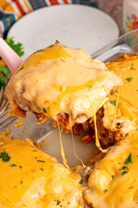 A spatula getting a large serving of Taco Rice Casserole from the baking dish.