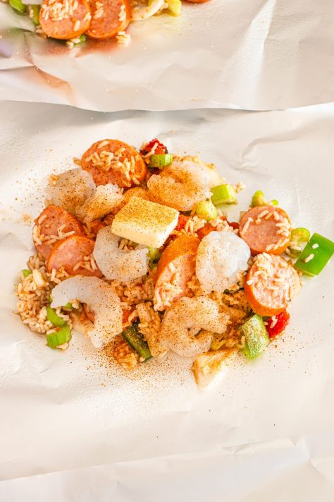 A pad of butter on top of a Jambalaya mixture.