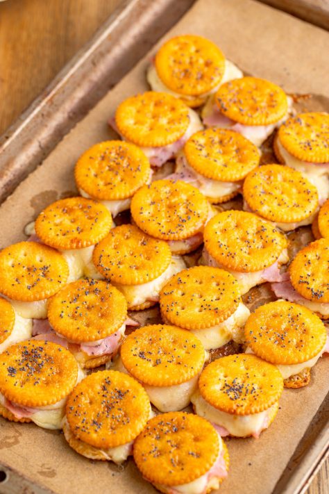 Baked Ritz Cracker Sandwiches on a lined baking sheet.