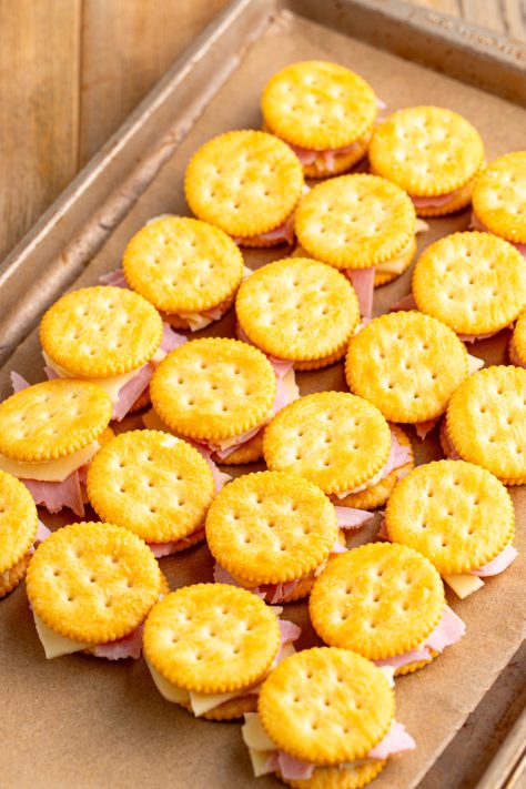 Unbaked Cracker Sandwiches on a lined baking sheet.