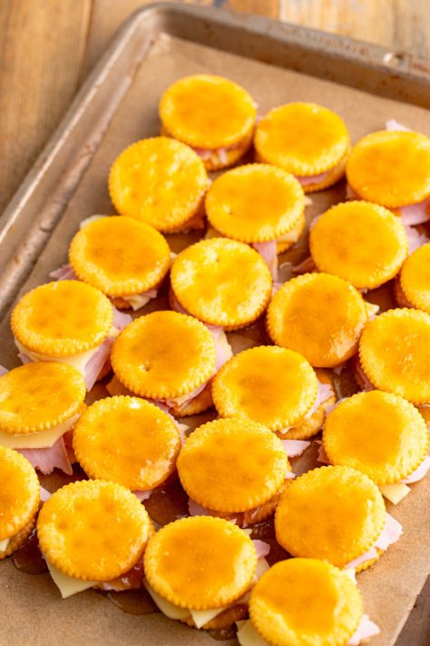 The sauce mixture over unbaked Ritz Cracker Sandwiches.