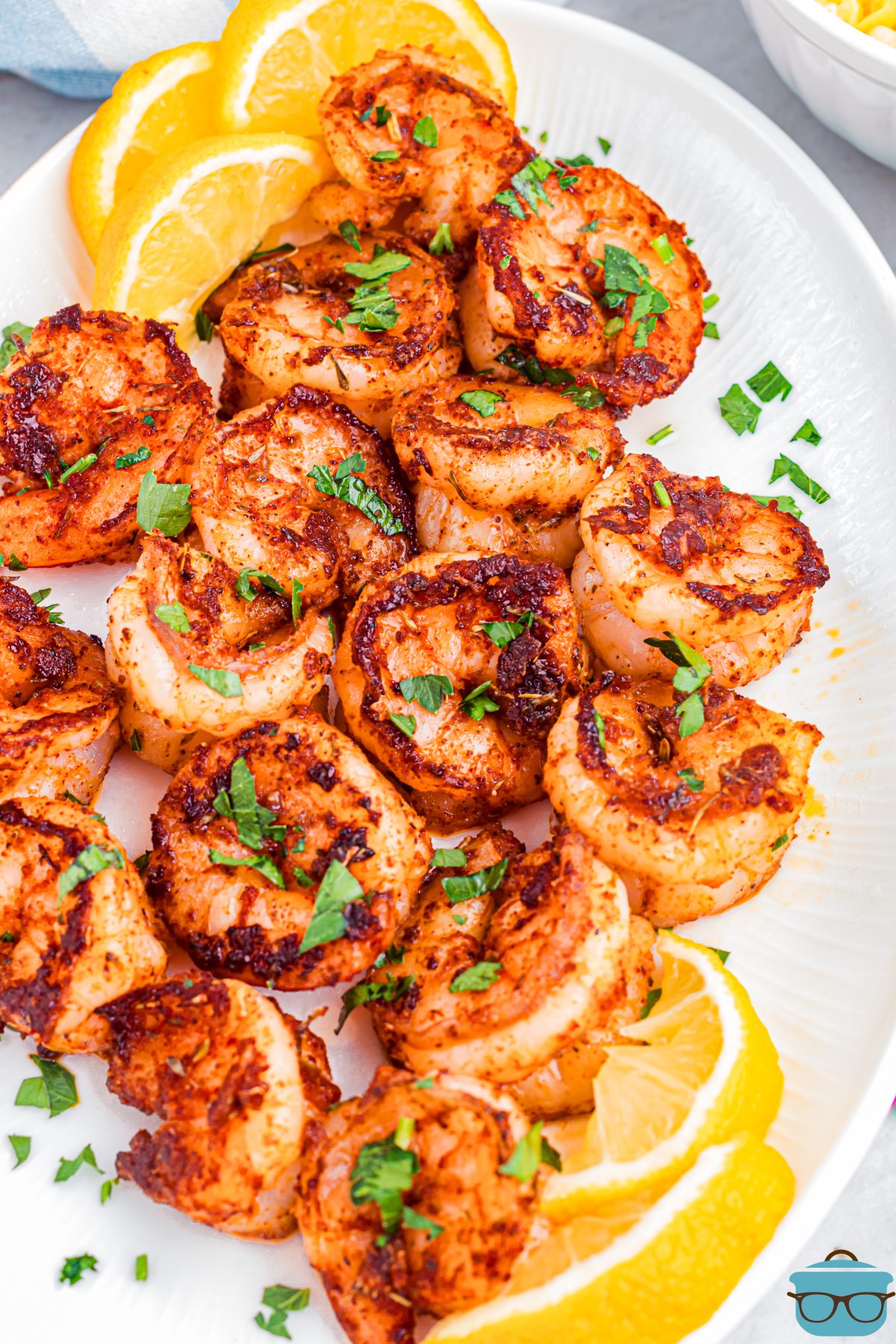 A plate with a few lemon wedges and some Blackened Shrimp.