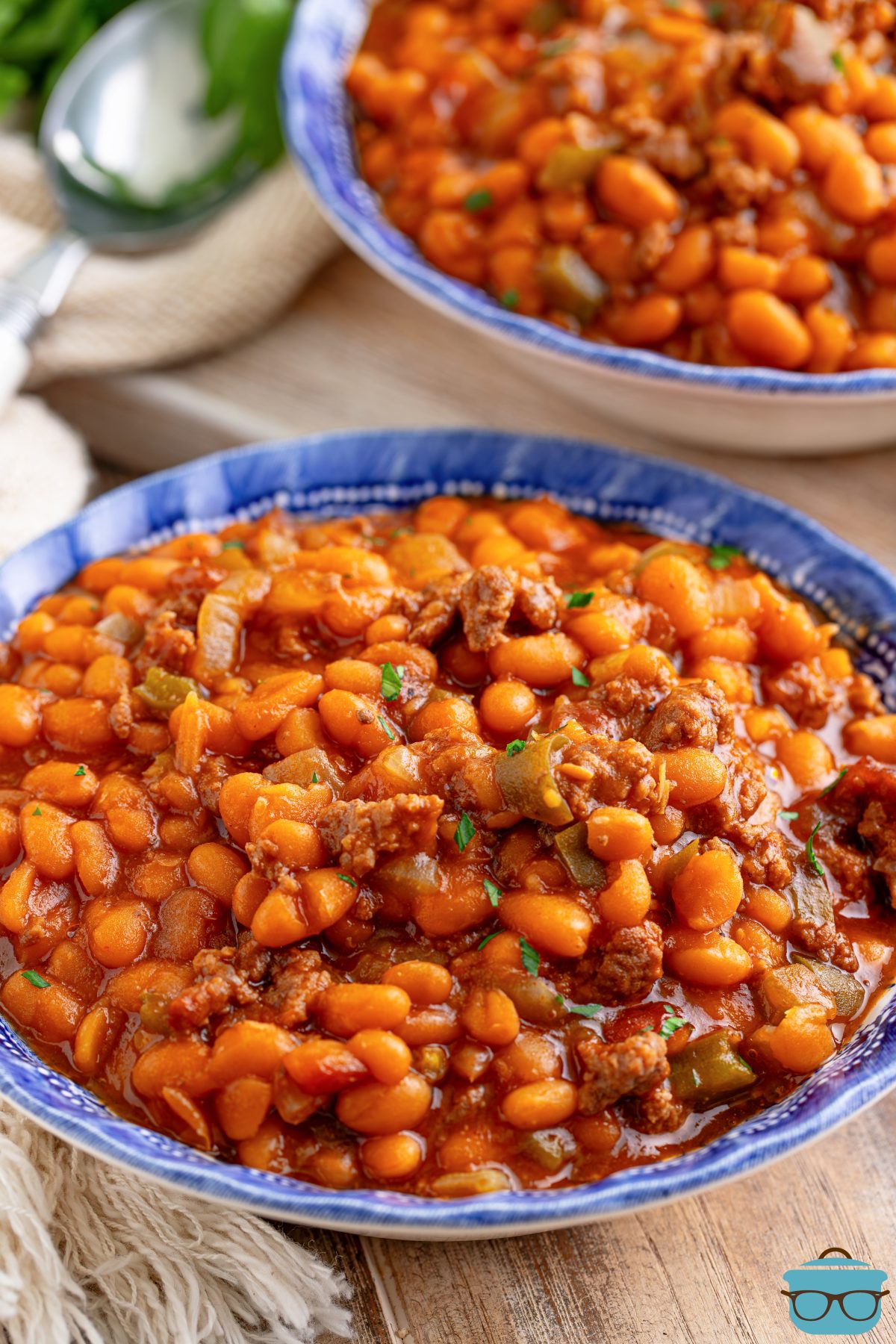 A big blue serving bowl of Cowboy Baked Beans.