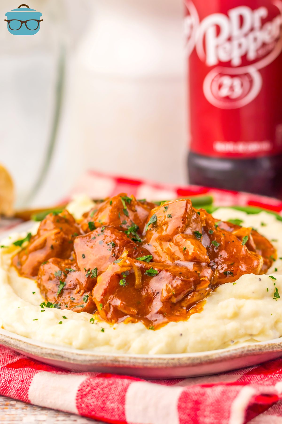 A bottle of Dr Pepper next to a pile of Dr Pepper Rib Bites with sauce on a pile of mashed potatoes.