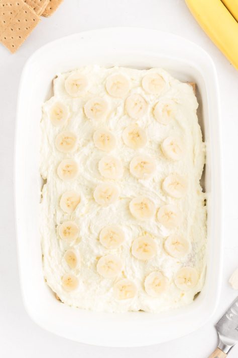 A dessert dish with layers of graham crackers, pudding mixture, and bananas.