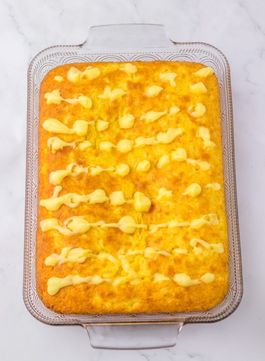 A cake with pudding in the holes.