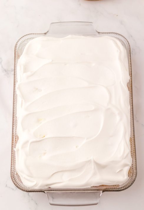 Whipped topping over a cake with pudding.
