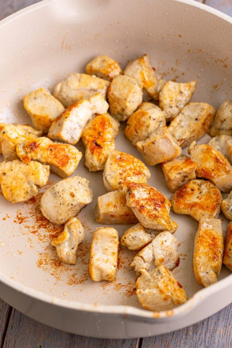 Chicken searing in a pan.