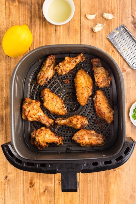 Cooked wings in an Air Fryer basket.