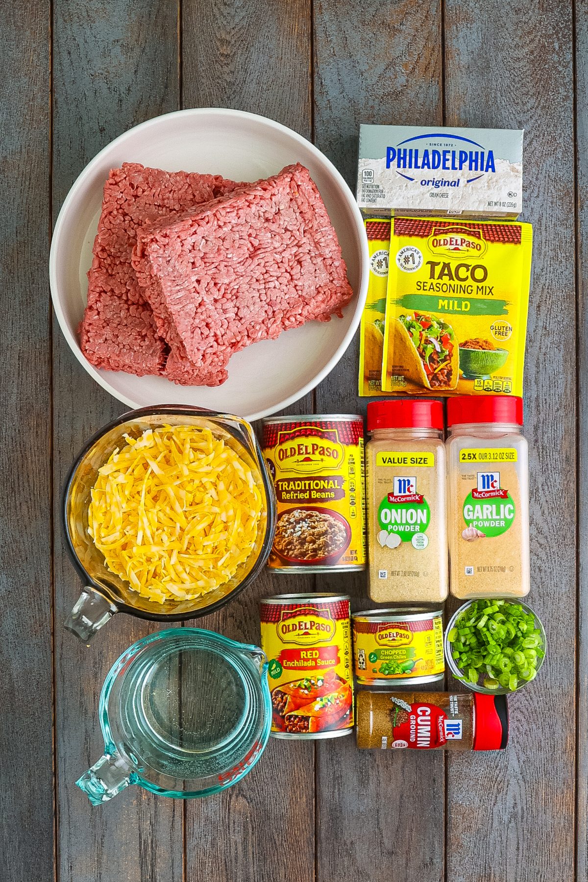 Ground beef, taco seasoning, garlic powder, onion powder, ground cumin, water, red enchilada sauce, refried beans, cream cheese, shredded Colby Jack cheese, green onions, and green chiles.