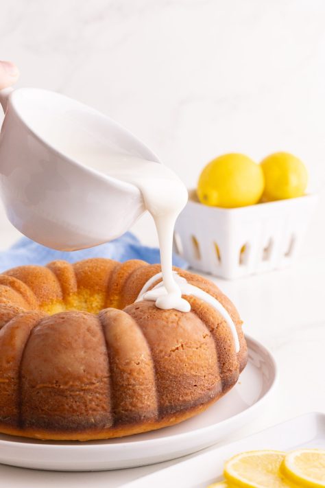 Homemade glaze being poured over a Lemon Pound Cake.
