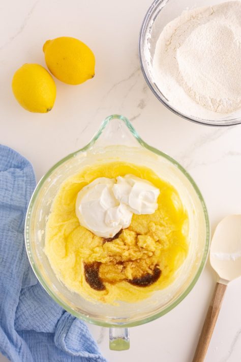 Sour cream and vanilla extract being added to a batter.