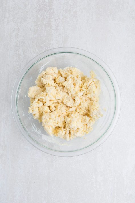 Cobbler topping being formed in a bowl.