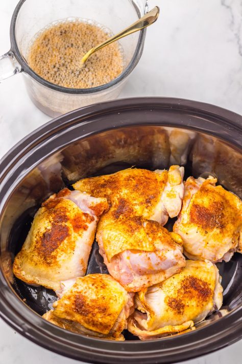 Browned chicken thighs in a Slow Cooker.
