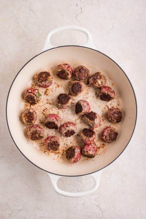 Meatballs cooking in a saucepan.