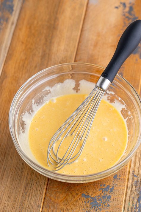 A whisk that just whisked Teriyaki Salad Dressing in a bowl.