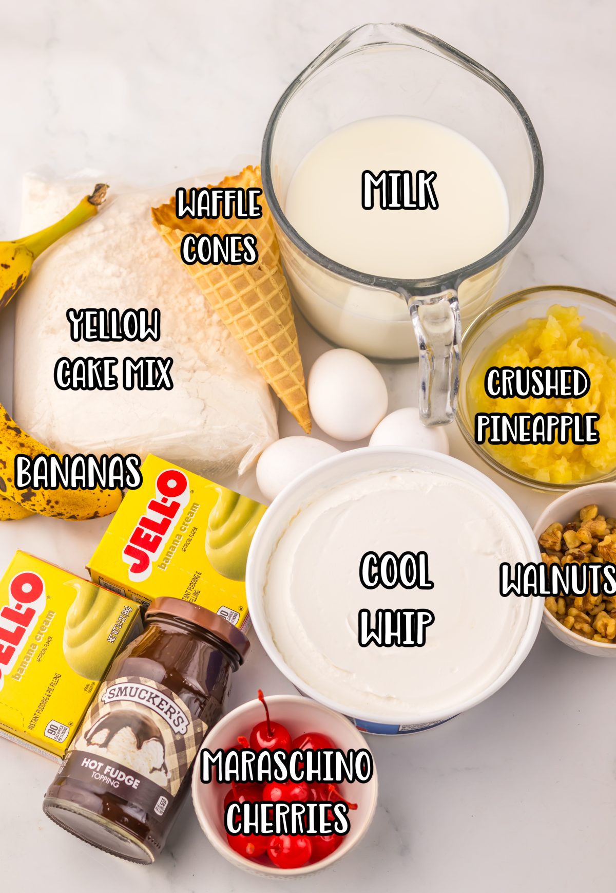 Yellow cake mix, crushed pineapple, instant banana cream pudding mix, cold milk, whipped topping, bananas, hot fudge sauce, chopped walnuts, crushed waffle cone pieces, and maraschino cherries.