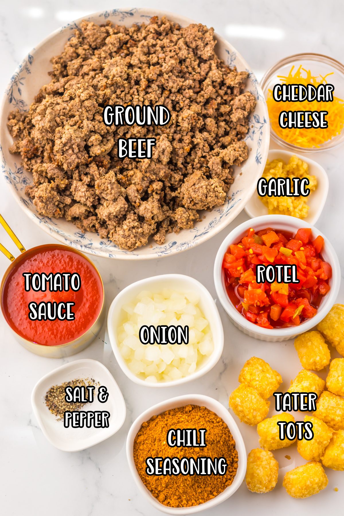 Ground beef, onion, salt, black pepper, mild chili seasoning, garlic, diced tomatoes with green chiles, tomato sauce, frozen tater tots, shredded cheddar cheese, and green onions.