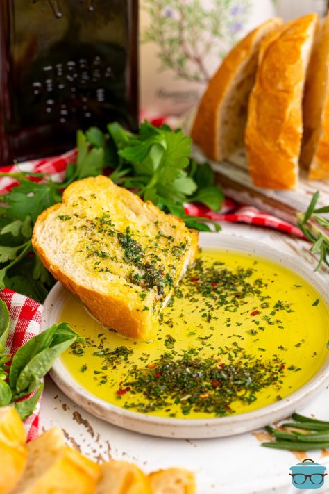 A plate of Herb Dip and oil with a slice of bread.