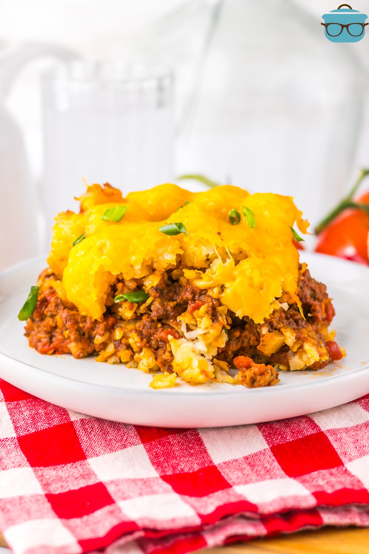 A plate on a cloth with a serving of Crock Pot Chili Cheese Tater Tot Casserole.