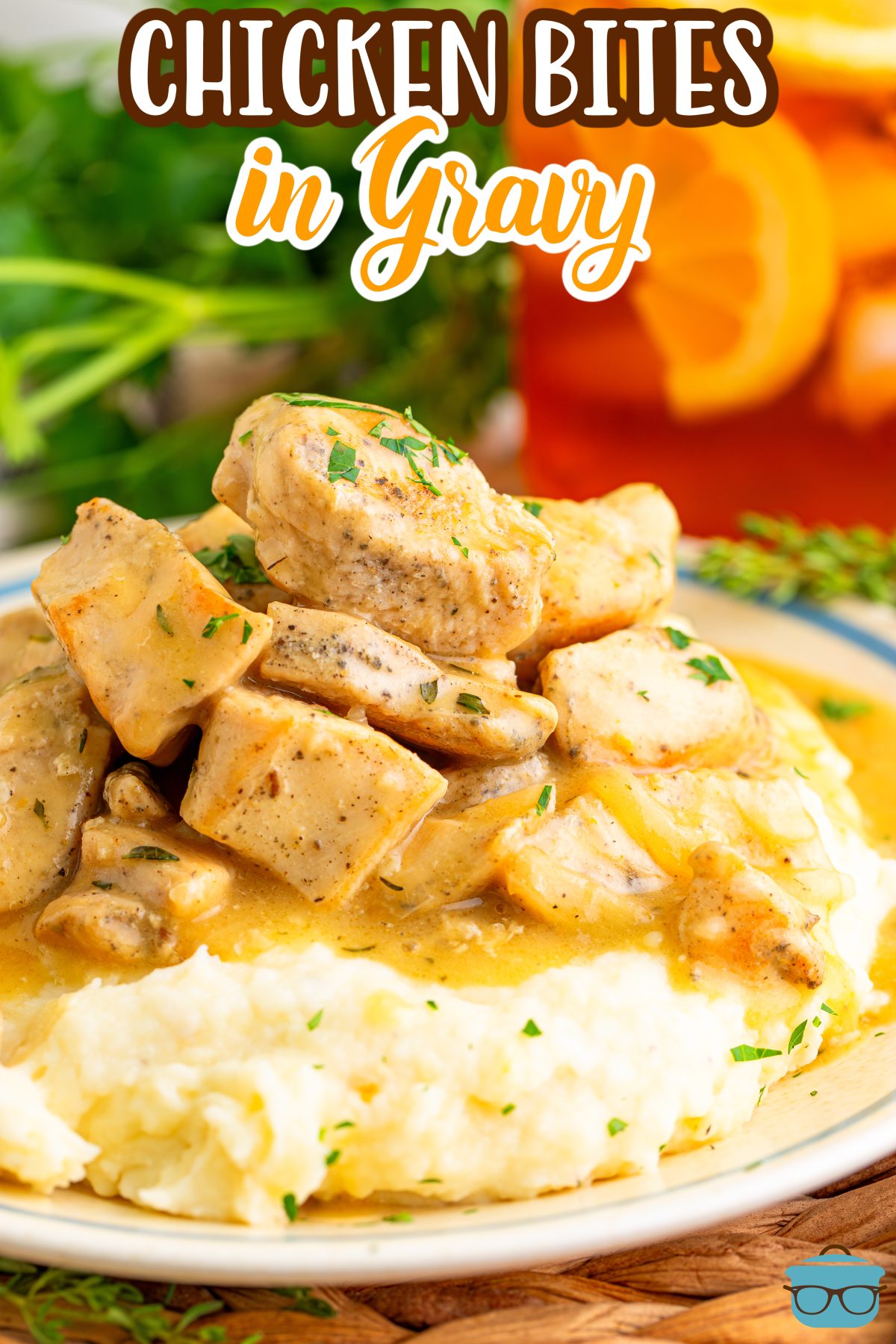 An overflowing plate of mashed potatoes and gravy with chicken bites.