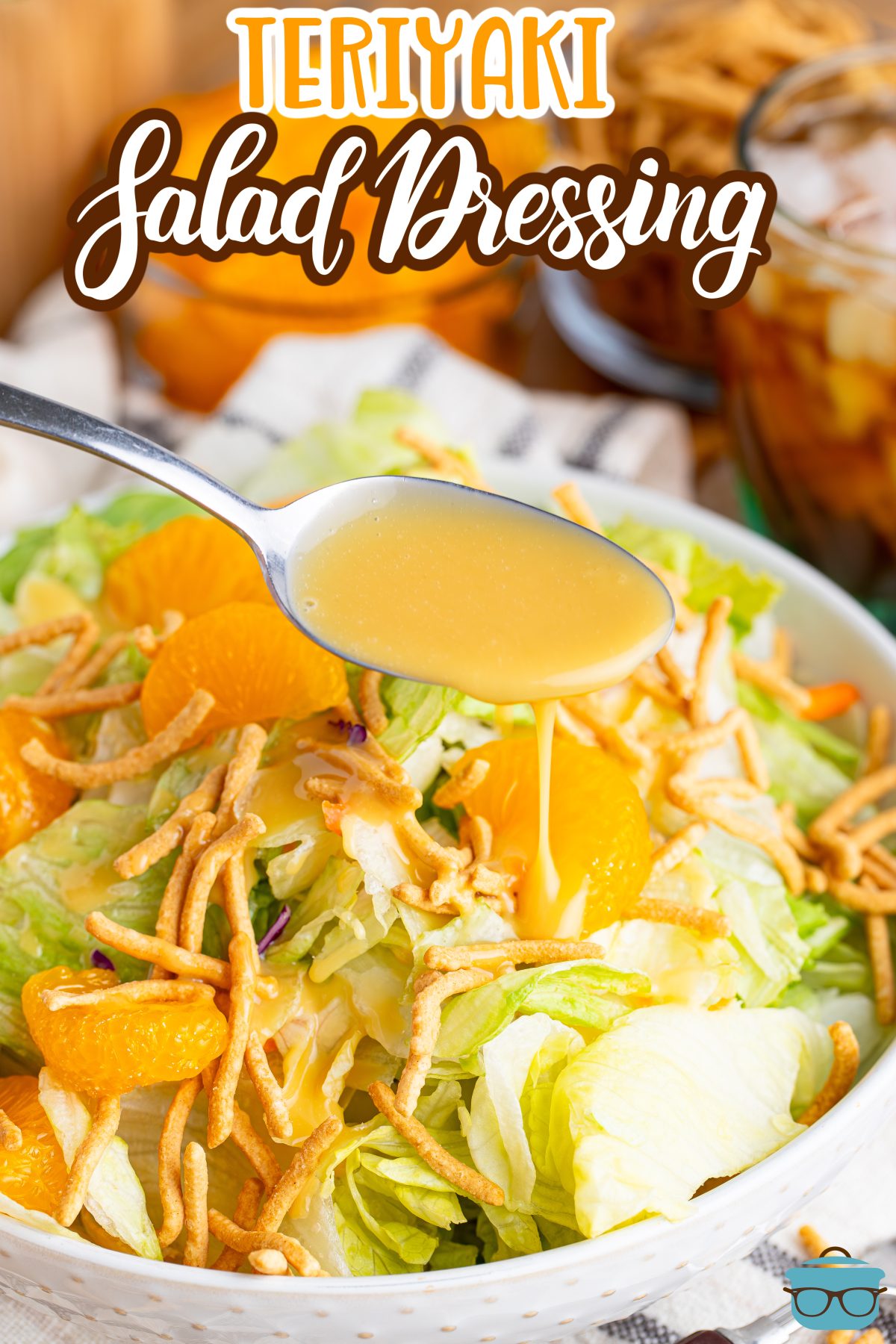 A spoon drizzling some Homemade Teriyaki Salad Dressing over a salad.