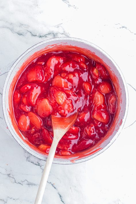 A thick strawberry filling in a saucepan.