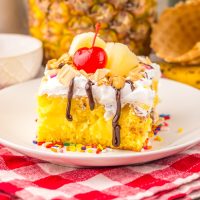 A dessert plate with a slice of Banana Split Poke Cake.