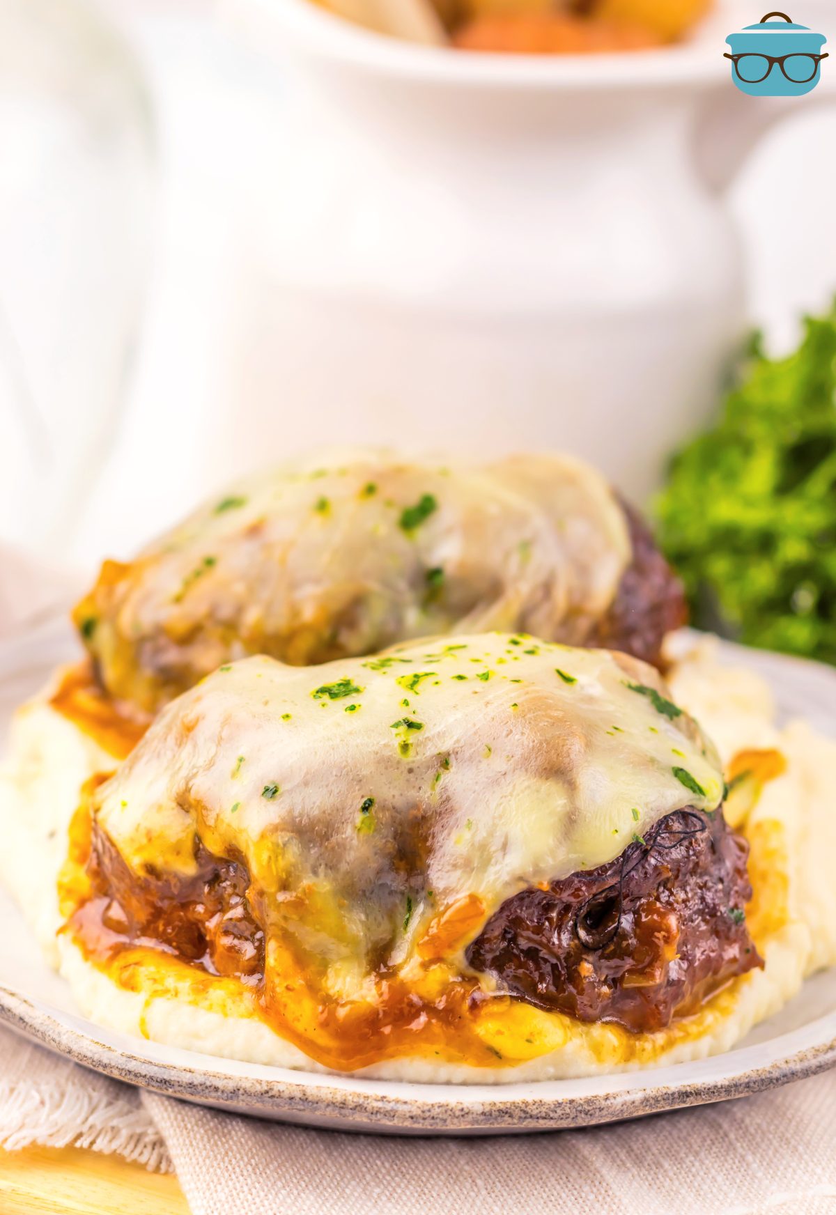 A white plate with a serving of Crock Pot French Onion Salisbury Steak.