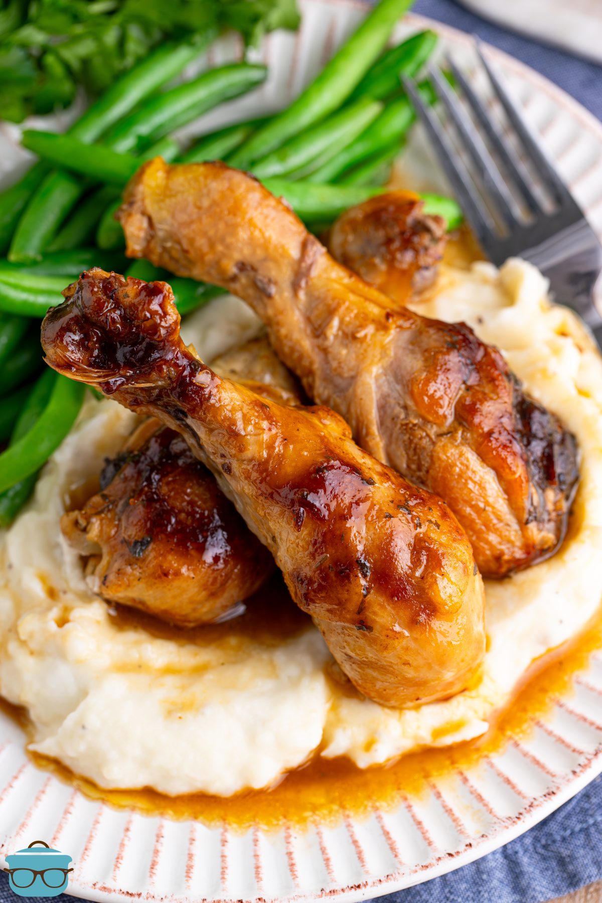 A plate with green beans, mashed potatoes, and Mississippi Chicken Legs.