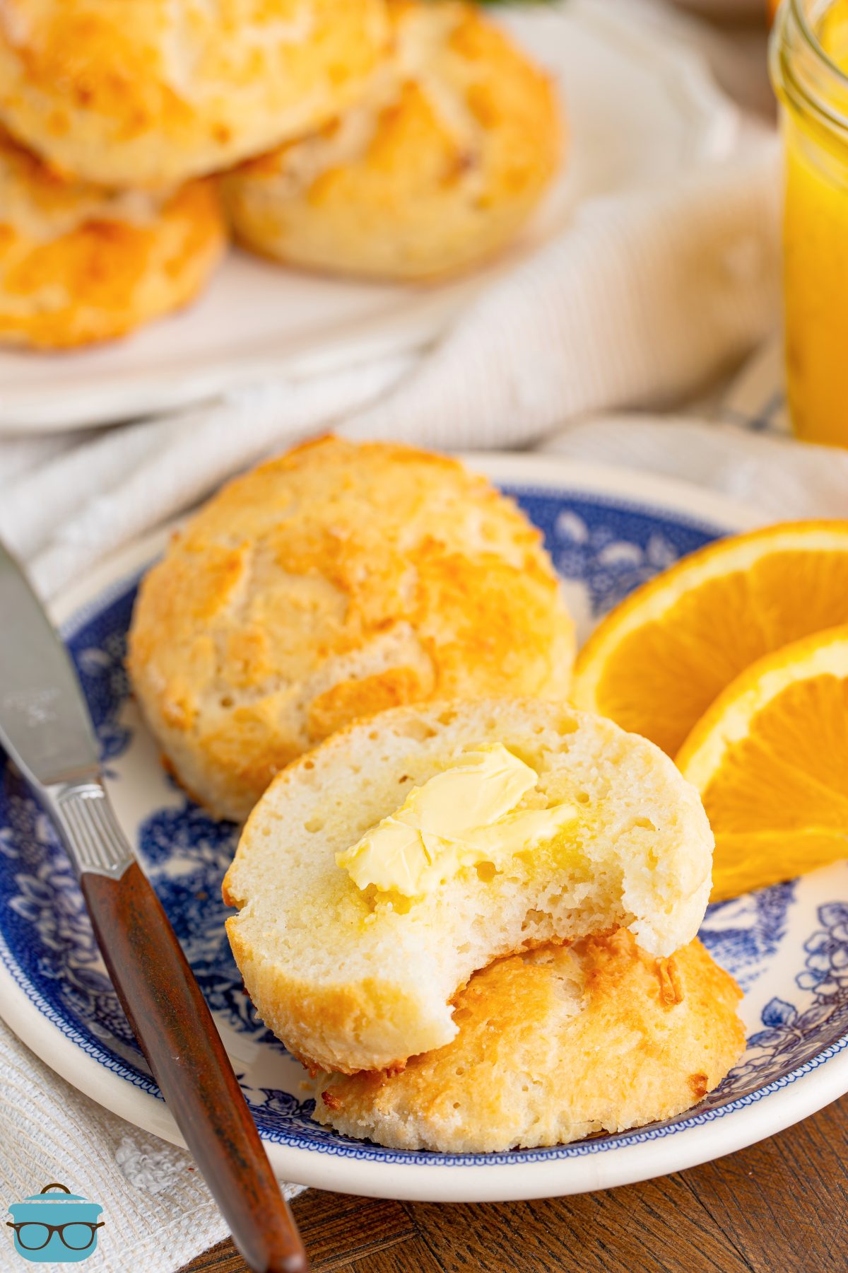 An open Two Things Biscuit with butter and a bite taken out.