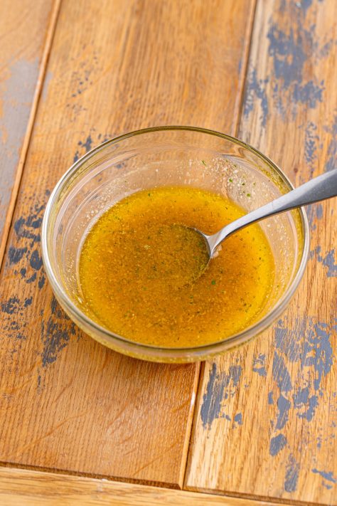 Melted butter and seasonings in a dish being mixed.