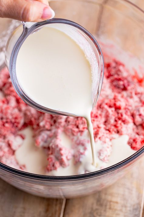 Heavy cream being added to a Cherry Pie Butter Dip Biscuit mix.