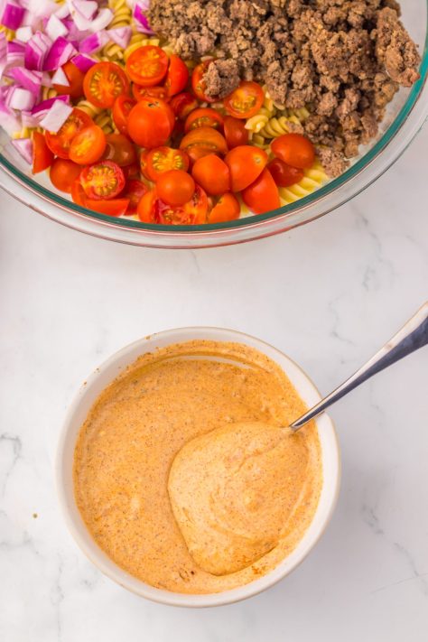 A mayo seasoned sauce being mixed in a bowl.