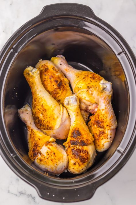 Seared drumsticks in sauce in a Slow Cooker.