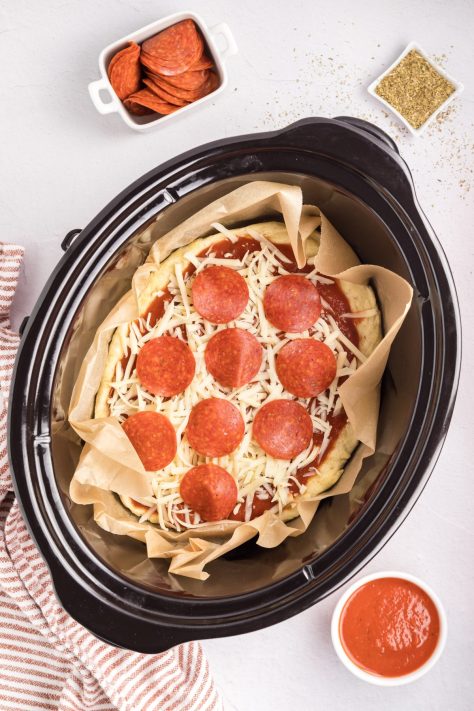 An assembled, unbaked Deep Dish Pizza in a Slow Cooker.