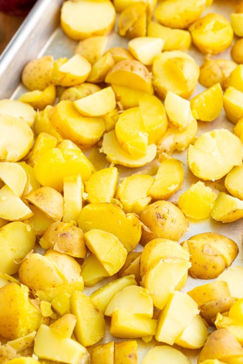 A sheet pan with cut up potatoes.