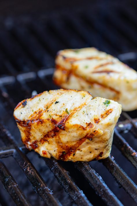 Grilled Sea Bass sitting on the grill grates.